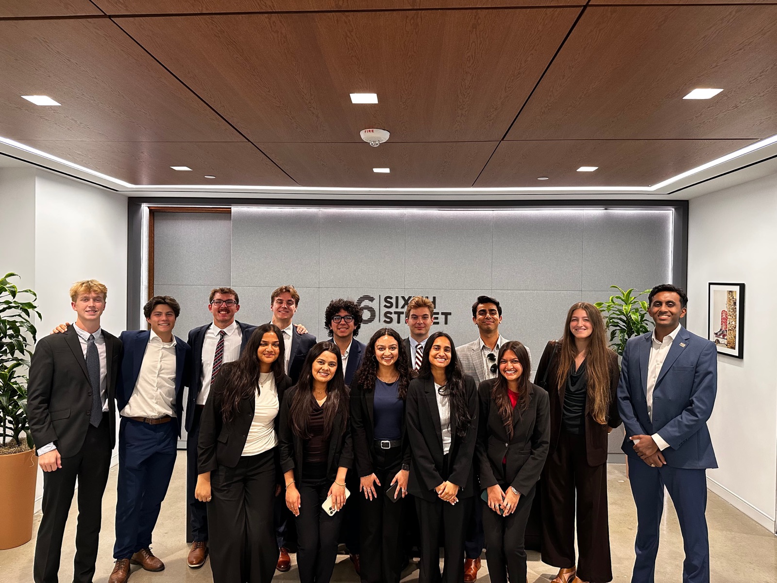 The group in front of the Sixth Street sign at their Austin office